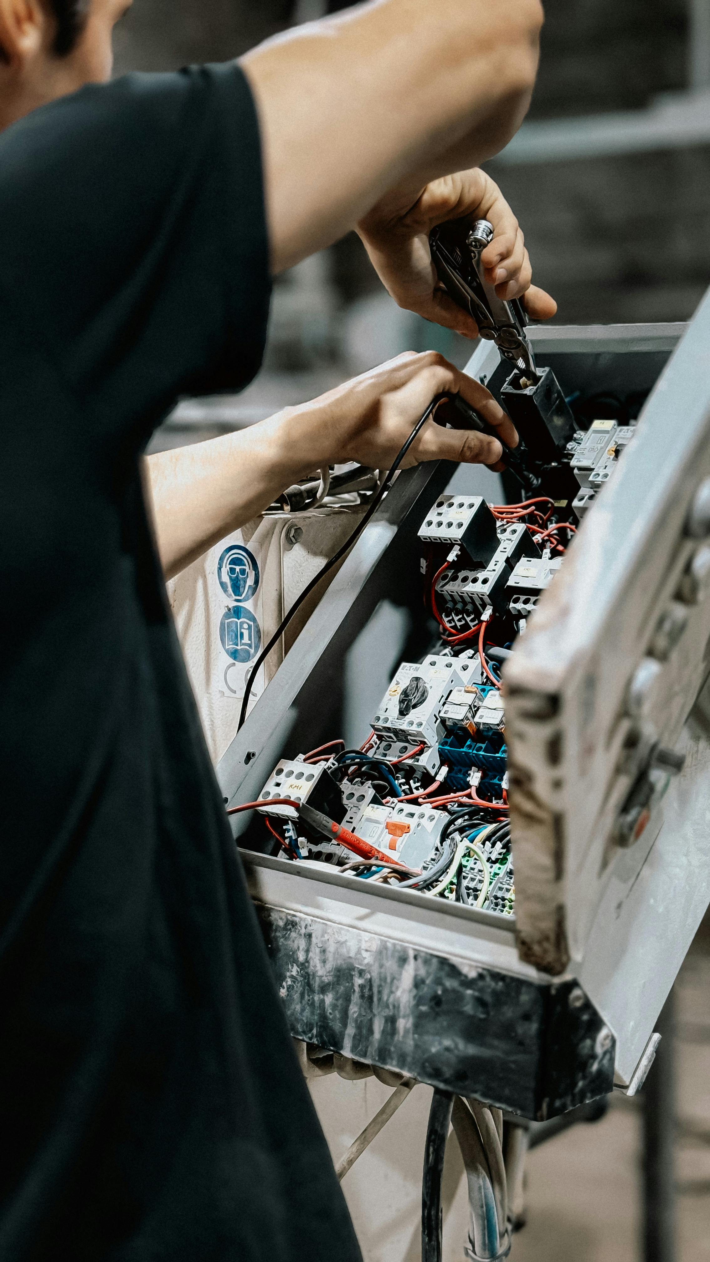 Technician working on electrical control equipment