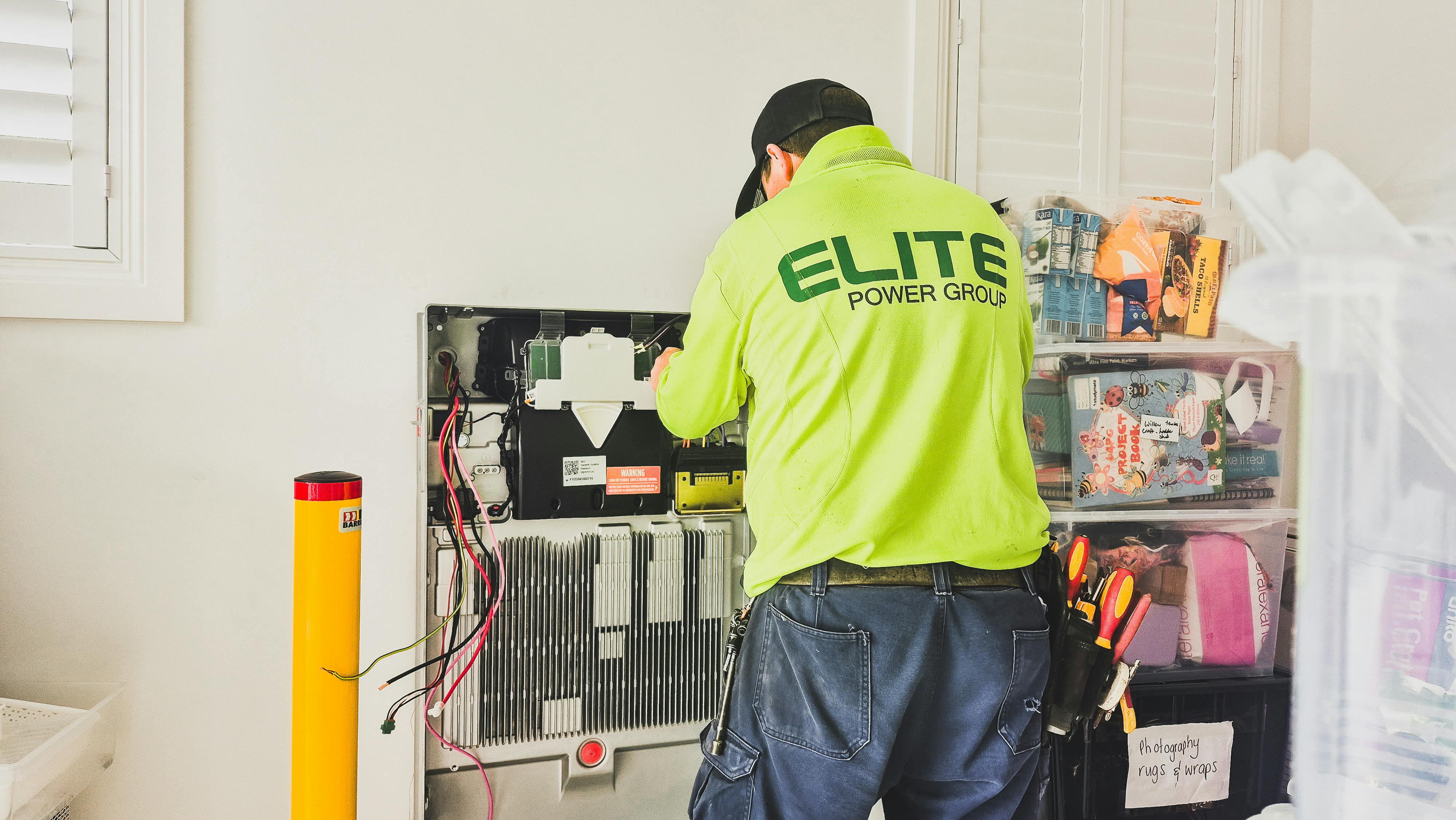 Technician installing a home battery system indoors