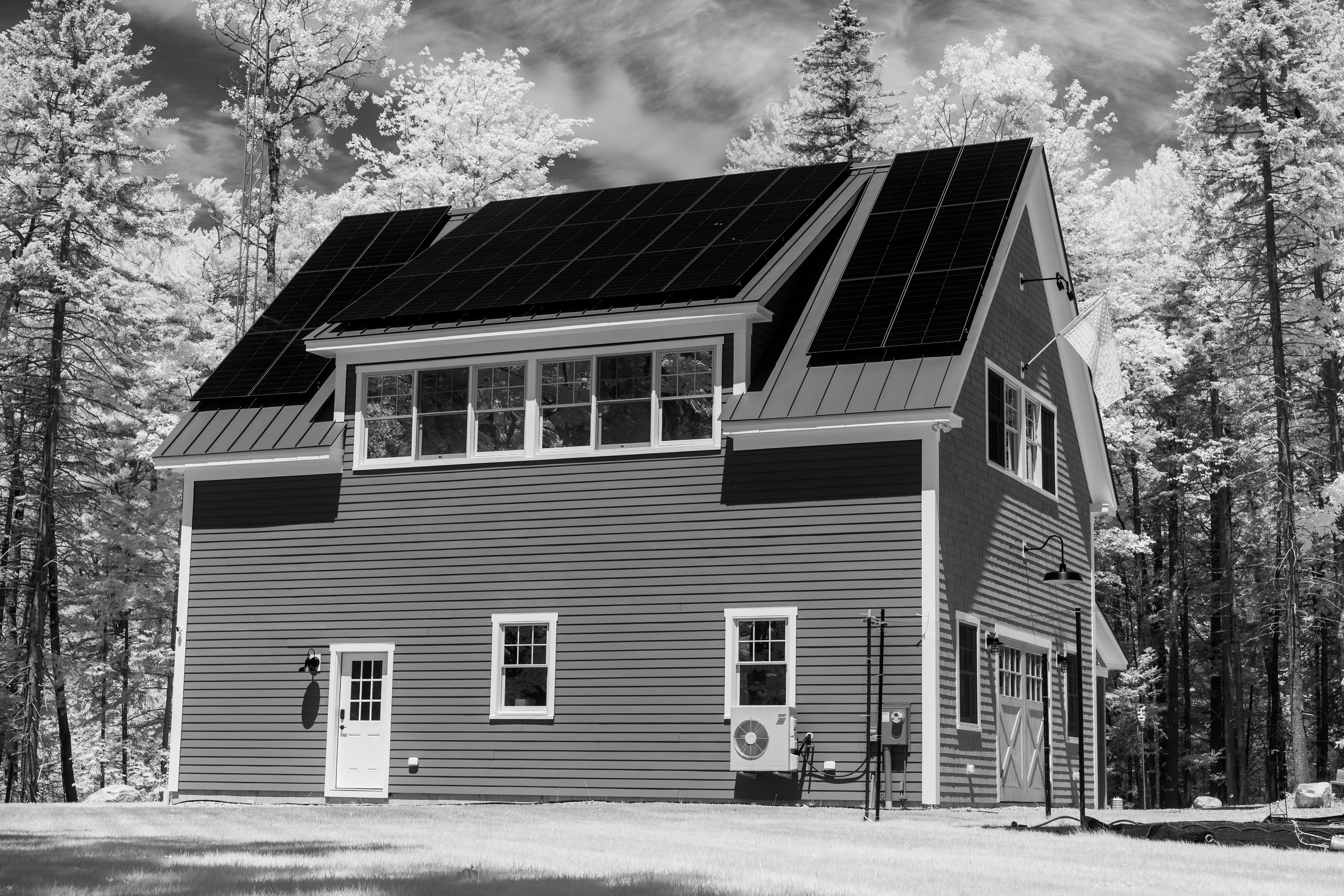House in a wooded setting with rooftop solar panels