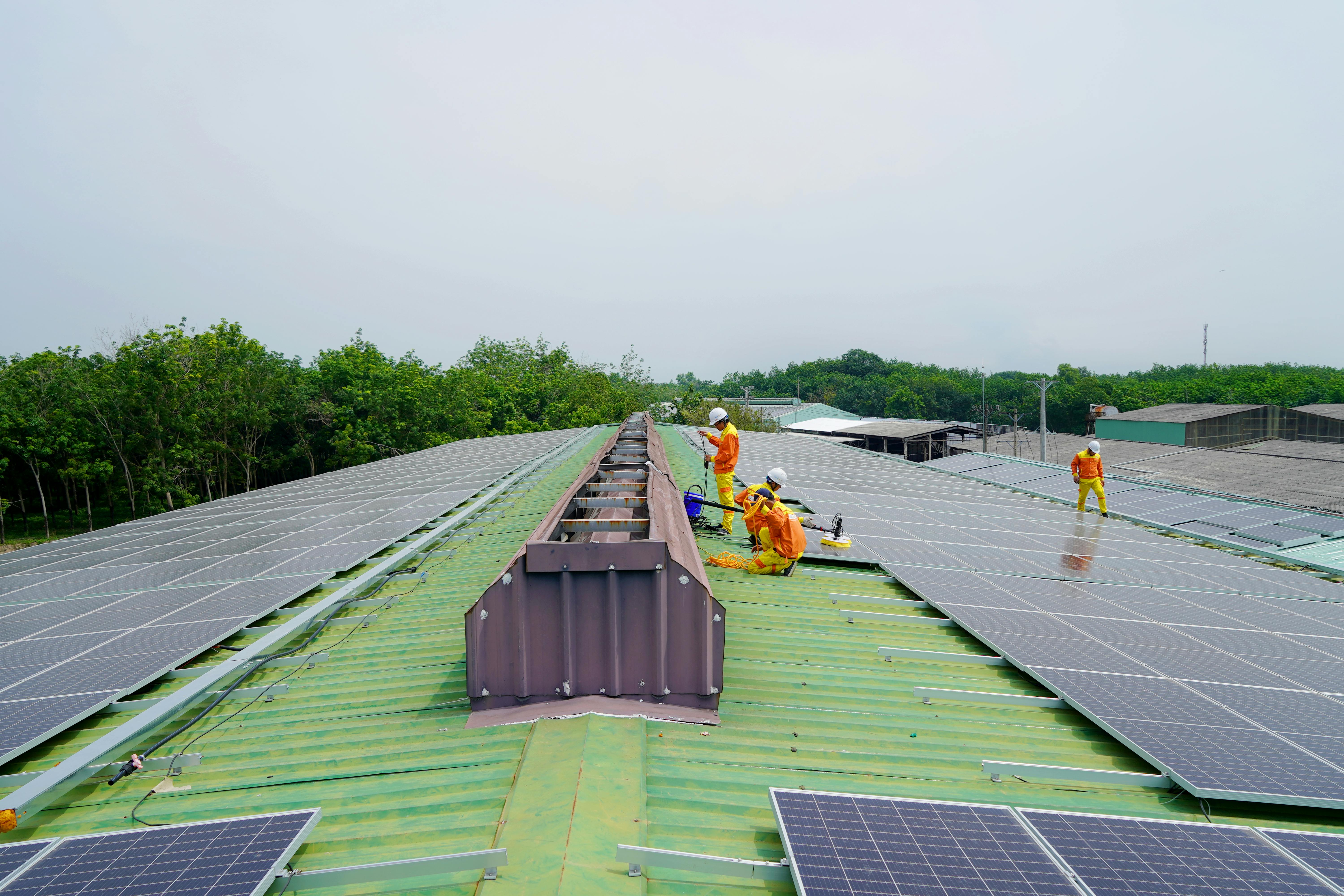 Technicians working across a large rooftop solar installation